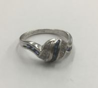 An 18 ct white gold diamond and sapphire ring Of swirling banded form. 8 cm high.