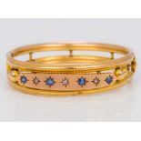 A 9 ct gold sapphire and diamond set bangle form bracelet Of pierced tubular form,