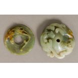 Two Chinese carved jade roundels Both worked with mythical beasts. The larger 7 cm diameter.