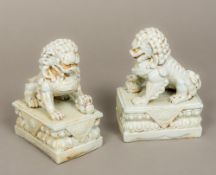 A pair of Chinese porcelain dogs-of-fo Each typically modelled in allover blue/white glaze.