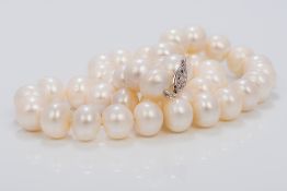 A pearl bead necklace Set with a pierced 14K white gold clasp. 42.5 cm long.