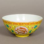 A Chinese porcelain bowl Worked with dragoon medallions within lotus strapwork on a yellow ground,