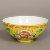 A Chinese porcelain bowl Worked with dragoon medallions within lotus strapwork on a yellow ground,