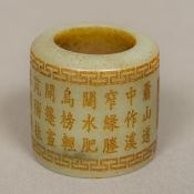 A jade archer's ring Of typical form, with calligraphic decorations. 3.75 cm high.