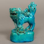A Chinese porcelain temple lion With all over turquoise glaze. 14 cm high.