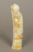 A Chinese carved celadon jade model of Shou Lao Typically modelled holding a fruit and a staff,