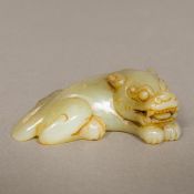 A Chinese carved jade group Worked as a recumbent temple lion and a bat. 9 cm wide.
