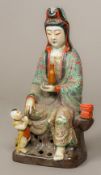 A Chinese porcelain figural group formed as Guanyin Modelled seated holding a vase and a young