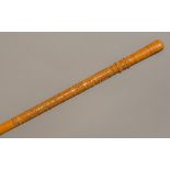 A carved and inlaid walking stick The top half decorated in the round with various carved bandings