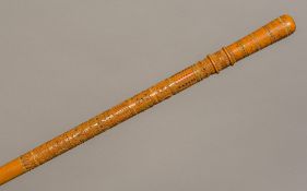 A carved and inlaid walking stick The top half decorated in the round with various carved bandings