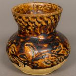 A Chinese Tang Dynasty pottery vase With moulded decoration and treacle glaze.