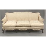 A late 19th/early 20th century mahogany framed three seat upholstered settee The overstuffed shaped
