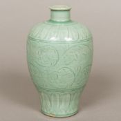 A Chinese porcelain vase Of baluster form, with incised decoration on a celadon ground. 21 cm high.
