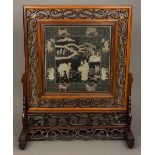 A late 19th/early 20th century Chinese carved hardwood table screen Of large proportions,