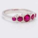 An 18 ct white gold diamond and ruby ring With five facet cut circular set rubies interspersed with