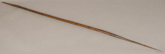 An African tribal spear Of double ended form with carved decoration to the top of the shaft.