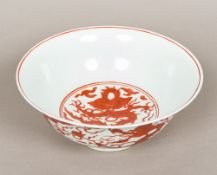 A Chinese porcelain bowl Decorated with dragons chasing flaming pearls amongst stylised clouds,