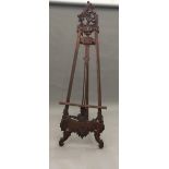 A decorative carved wooden picture easel 215 cm high.