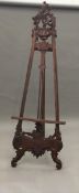 A decorative carved wooden picture easel 215 cm high.