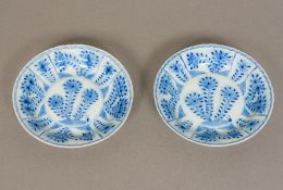 A pair of Chinese blue and white porcelain saucers Each floral decorated within a crimped rim,