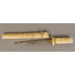 A 19th century Japanese carved bone tanto The handle and scabbard typically worked with figures in