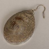 A 19th century white metal mounted well carved coconut pendant Worked with an alpine scene within