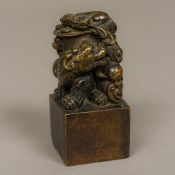 A Chinese cast bronze seal Modelled with two dogs-of-fo and with a calligraphic matrix. 12 cm high.