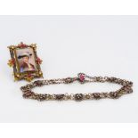 A Victorian gilt metal gem set brooch Centred with a porcelain plaque decorated with a bust of a