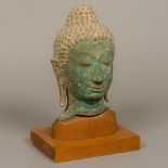 An antique bronze bust of Buddha Typically modelled wearing a headdress and with extended earlobes,