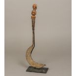 An African tribal sickle The iron implement of typical form with twisted stem,