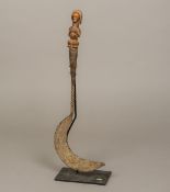 An African tribal sickle The iron implement of typical form with twisted stem,