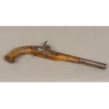 A 19th century Eastern percussion cap pistol The stock with metal stud decoration. 40 cm long.