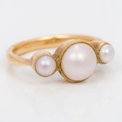 An 18 ct gold three pearl ring 9mm high.