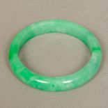 A Chinese carved jade bangle 8 cm diameter.