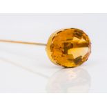 A citrine set hatpin The large facet cut stone set in an unmarked gold mount. 17.5 cm long.