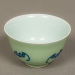 A Chinese porcelain tea bowl The exterior decorated with a band of bats on a celadon ground,