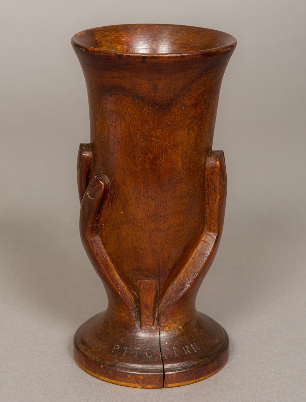 A Pitcairn Islands turned wooden vase Formed as a spread hand holding aloft a vase,