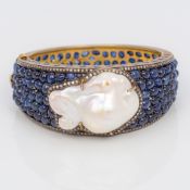 A Faberge type gold, diamond, sapphire and baroque pearl set hinged bangle,