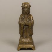 A Chinese bronze figure of an attendant Modelled hands crossed and wearing a headdress.