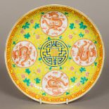 A Chinese porcelain dished plate Worked with dragon medallions within lotus strapwork on a yellow