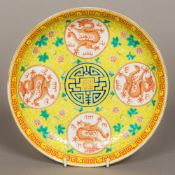 A Chinese porcelain dished plate Worked with dragon medallions within lotus strapwork on a yellow