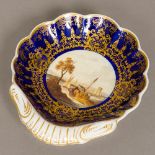 A 19th century English porcelain dish Well painted with shipping in an estuary landscape within a