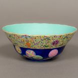 A Chinese porcelain bowl Decorated with various roundels on a blue ground below a lotus strapwork