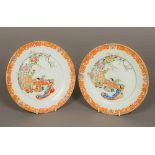 A pair of Japanese porcelain plates Each enamel and gilt decorated with figures in a fenced garden.