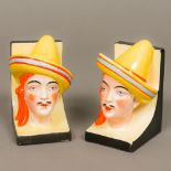 A pair of Continental Art Deco porcelain bookends Each formed as a male bust wearing a strike hat.