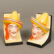 A pair of Continental Art Deco porcelain bookends Each formed as a male bust wearing a strike hat.