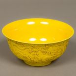 A Chinese yellow ground porcelain bowl The exterior decorated in the round with dragons chasing