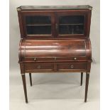 A 19th century brass mounted mahogany cylinder bureau The upper section with three-quarter pierced