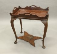 An Edwardian 18th century style mahogany silver table The shaped pierced tray style top supported