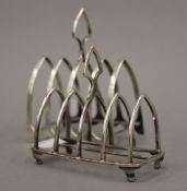 Two small silver toast racks (3.8 troy ounces). Larger 8.